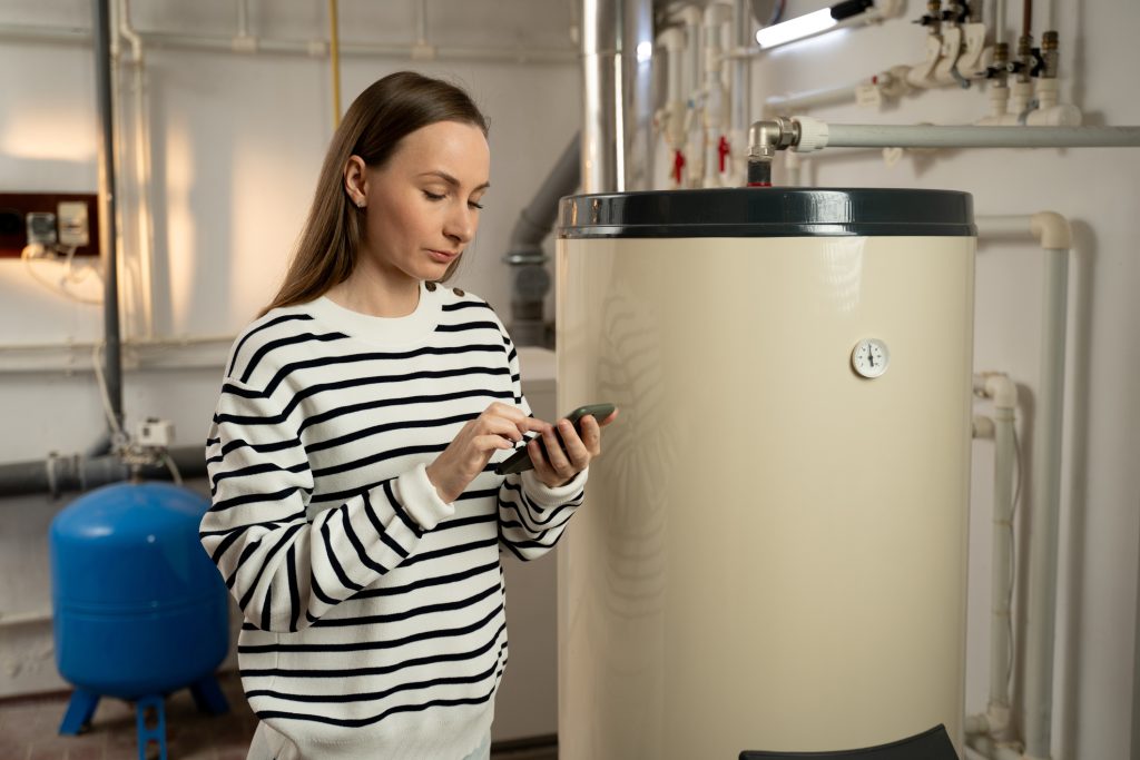 A young woman troubleshooting water heater problems in winter in Michigan.
