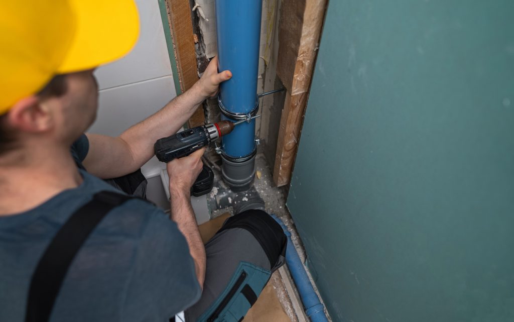 Rooter MD plumber repairing a pipe during a slab leak repair in a Metro Detroit home.
